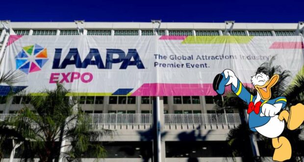Donald Duck greets expo guests with his signature enthusiasm in front of the vibrant IAAPA Expo 2022 banner under clear blue skies.
