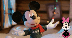 Mickey Mouse greets guests in a cozy sweater and bright red scarf inside a festive Disney World setting, while a delightful Minnie Mouse cartoon adds extra magic in the lower right corner.