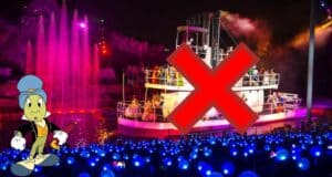 The Fantasmic! riverboat glides across the lagoon under the night sky, but a bold red X marks it as canceled or unavailable. Jiminy Cricket stands to the left, looking on with concern.
