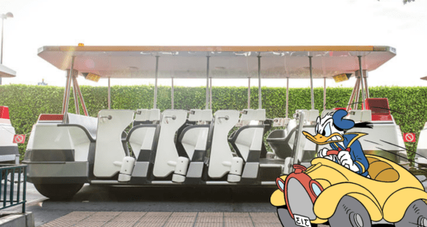 Donald Duck takes the wheel of a colorful cartoon car, cruising past an empty Walt Disney World parking tram under bright, sunny skies.