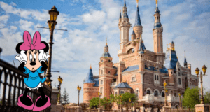 Minnie Mouse greets visitors in front of the iconic fairytale castle with its sparkling blue rooftops, set against a dramatic cloudy sky at Shanghai Disneyland, highlighting the park’s magical and immersive atmosphere.