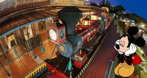 Mickey Mouse waves and smiles beside the vibrant red Walt Disney World Railroad train, ready to greet guests at the station in Magic Kingdom.