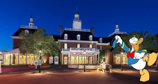 Donald Duck joyfully dancing outside the American Adventure Pavilion at EPCOT, illuminated by dazzling night lights and surrounded by lush trees.