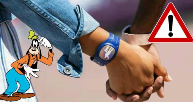 Guests clasp hands near a playful Goofy cartoon and a bold red warning sign with an exclamation mark—one guest shows off their MagicBand implant.