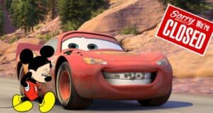 Mickey Mouse stands with a forlorn expression beside Lightning McQueen from Pixar Cars, under a prominent "Sorry, We're Closed" sign, embodying the unmistakable emptiness and disappointment fans feel when Disney Parks aren’t open.