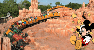 Big Thunder Mountain Railroad thrills guests as its train climbs dramatic red rock hills, packed with excited riders; on the right, Mickey Mouse adds Disney magic, highlighting the wild adventure of this iconic attraction.