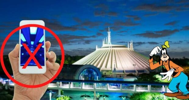 A guest’s phone shows an X mark in front of Space Mountain glowing at night, highlighting a memorable Disney PhotoPass experience as Goofy waves from the side.
