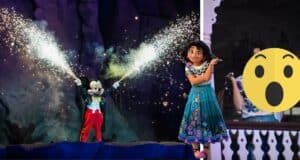 Mickey Mouse ignites the night with dazzling fireworks alongside Mirabel Madrigal from Encanto, while a shocked face emoji reacts to the spectacular Disney Fantasmic! show.