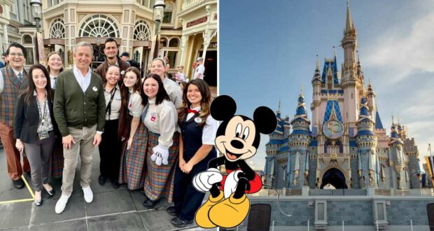 Guests gather in front of a Mickey Mouse graphic at Disney World, with the iconic Cinderella Castle standing to the right, capturing the magical atmosphere that Bob Iger has helped inspire across the park.