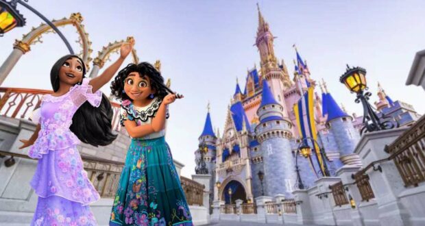 Mirabel and Isabela from Encanto, dressed in their signature colorful outfits, smile in front of Cinderella Castle at Magic Kingdom, capturing the excitement of a magical day after their Bibbidi Bobbidi Boutique transformation.