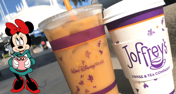 Two Disney-themed Joffrey’s Coffee cups and Minnie Mouse enjoying a mug, set against the backdrop of a charming park building, perfectly capture the whimsical ambiance and excitement of Walt Disney World.