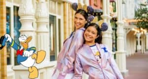Disney fans pose on Main Street wearing official Disney jackets and Minnie ear headbands, beaming with excitement as a cheerful Donald Duck cartoon completes the magical atmosphere.