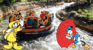 Daisy Duck in a bright yellow raincoat and Donald Duck with a red umbrella greet excited guests onboard Kali River Rapids, as the beloved water ride at Disney’s Animal Kingdom splashes back to life.