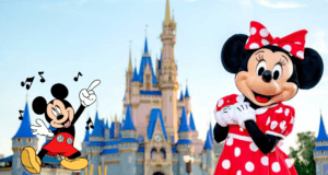 Mickey and Minnie Mouse pose together in front of the iconic blue and gold Cinderella Castle with a vivid blue sky above, embodying the magical atmosphere of Disney World.