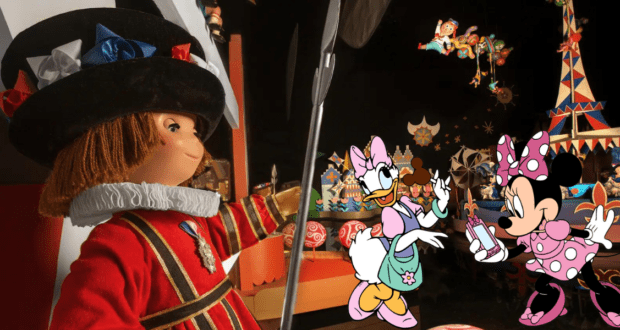 A Small World doll in a bright red costume stands beside Daisy Duck and Minnie Mouse, who are all smiles as they hold a gift, capturing the welcoming and inclusive magic of Disney parks.