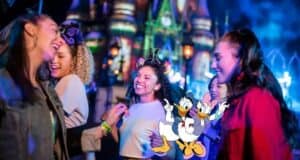 Four friends share a joyful evening in front of the illuminated Disney castle, joined by Daisy Duck and Donald Duck as part of the magical Disneyland experience.