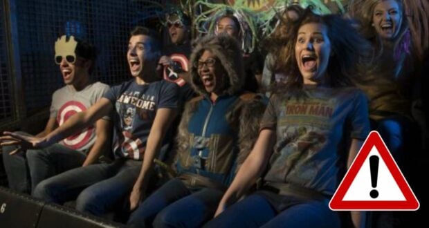 Marvel fans in Guardians of the Galaxy attire let loose with excited screams on an exhilarating ride at a theme park, captured in a TikTok-worthy thrill moment, with a warning icon featured in the bottom right corner.