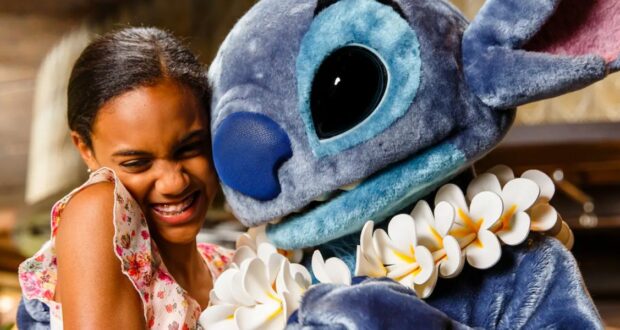 A beaming girl hugs Stitch, decked out in a festive white flower lei, capturing the kind of magical Ohana moment that makes Walt Disney World dining unforgettable.