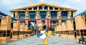 Donald Duck tipping his hat in front of a Disney park building adorned with statues of beloved Disney Most Admired Companies characters.