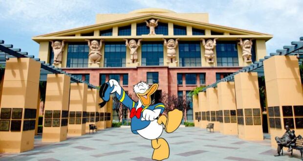 Donald Duck tipping his hat in front of a Disney park building adorned with statues of beloved Disney Most Admired Companies characters.