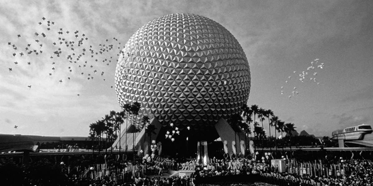A black-and-white photo of EPCOT’s geodesic dome, Spaceship Earth, with crowds gathered below and balloons in the sky, surrounded by palm trees—capturing classic park sights near World Showcase’s Impressions de France.