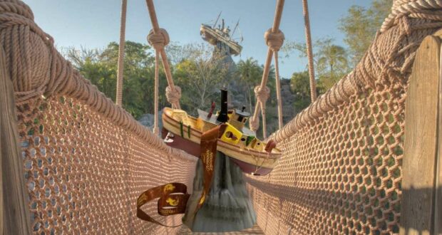 A whimsical scene at Disney’s Typhoon Lagoon features a toy boat and iconic Mickey ear hat perched on the rope bridge, with the Typhoon Tilly Sipper in view and Miss Tilly’s shipwreck atop Mount Mayday as a dramatic backdrop.
