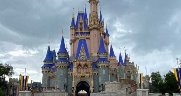 Cinderella Castle with its iconic blue spires stands tall beneath a cloudy sky at Walt Disney World Resort, creating a magical backdrop that enchants guests and sets the scene for mastering the art of navigating busy park days.