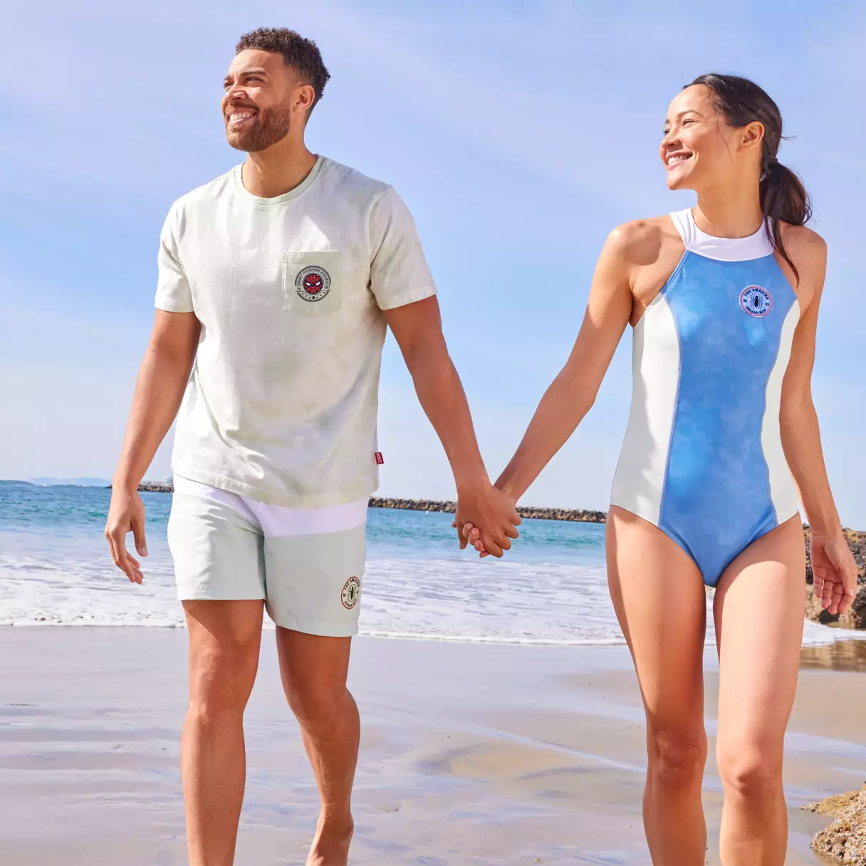 two people on the beach wearing disney merchandise