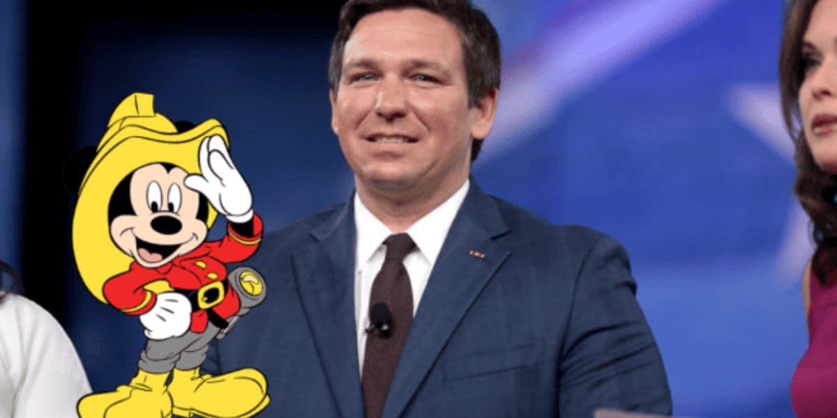 Mickey mouse on fire fighter outfit with DeSantis behind him