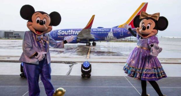 Mickey and Minnie standing in front of a Southwest Plane