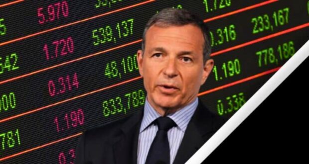 A man in a suit and striped tie speaks in front of a digital stock market display board showing various numbers and figures in red and green, including Disney Stock. The image has a diagonal white and black border on the right side.
