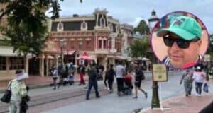 Guests walking down Main Street, U.S.A. at Disneyland. In the foreground is a screenshot from a video of a man discussing the Disney filming crackdown.