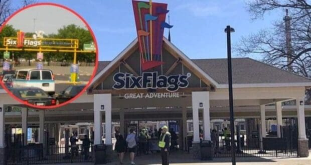 The entrance to Six Flags Great Adventure theme park, featuring the park's colorful logo above the gate. There are several people passing through the entrance. An inset shows the parking area with the "Six Flags" sign and parked cars, indicating this is a busy day.