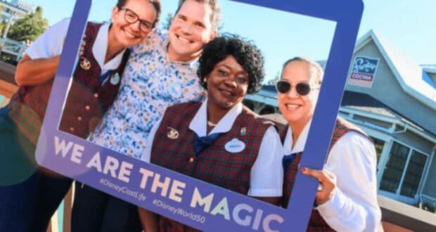 Disney cast members posing in a frame that reads "we are the magic"