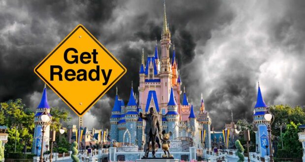 A dramatic image of a castle with dark storm clouds in the background. In the foreground, there's a yellow road sign that reads, "Get Ready." Statues of two characters holding hands stand in front of the castle, which has multiple spires with blue roofs.