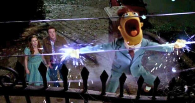 A Muppet character in a suit is getting electrocuted on a fence.