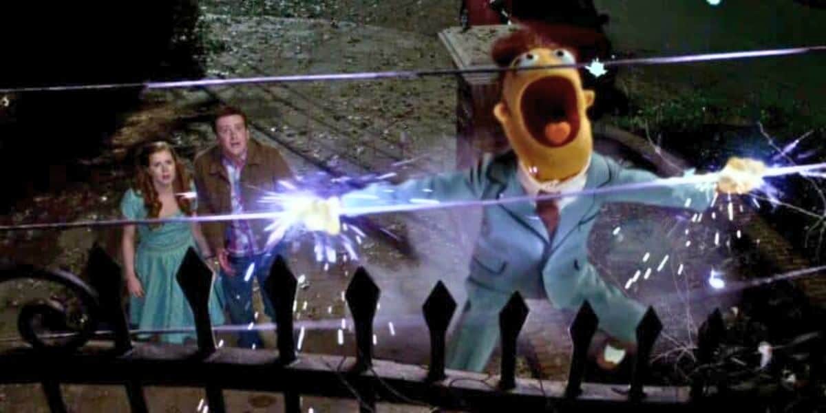 A Muppet character in a suit is getting electrocuted on a fence.