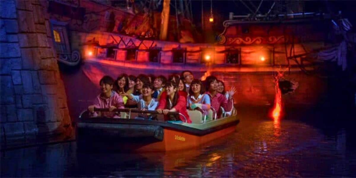 Guests riding a Pirates of the Caribbean boat at Tokyo Disneyland.