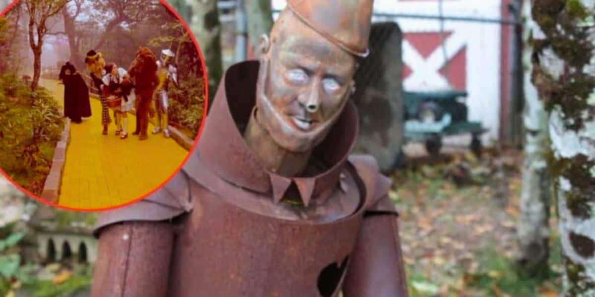 A close-up of a rusted Tin Man statue, with peeling paint and visible wear, set in an outdoor area surrounded by trees. In the top left corner, there is an inset of characters from "The Wizard of Oz" walking on the yellow brick road.