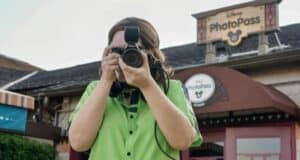 A Disney cast member taking a picture with a PhotoPass camera.