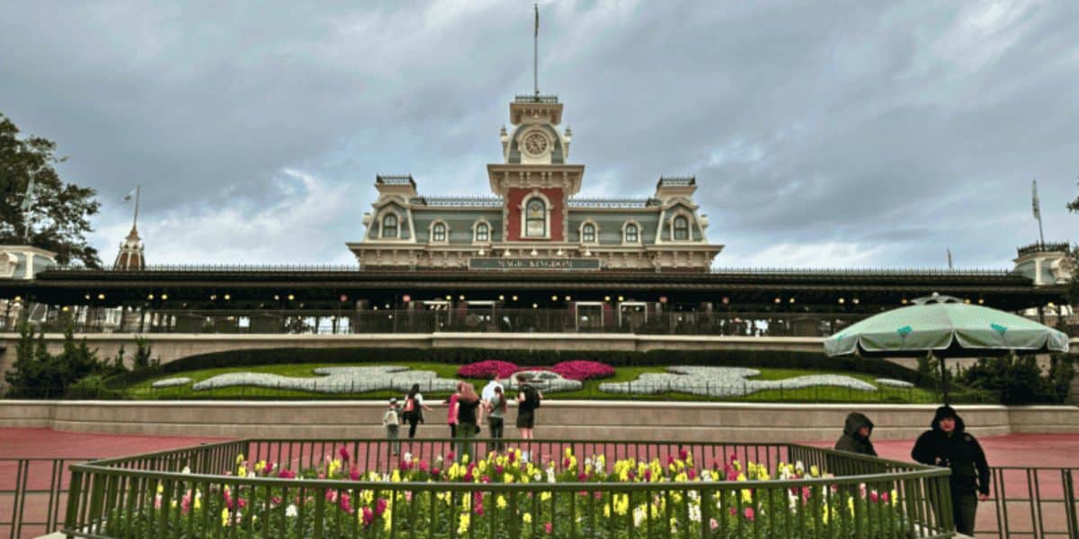 The Walt Disney World Railroad boarding station near the entrance of Magic Kingdom on Main Street, U.S.A., during a cloudy day with guests and security cast members.