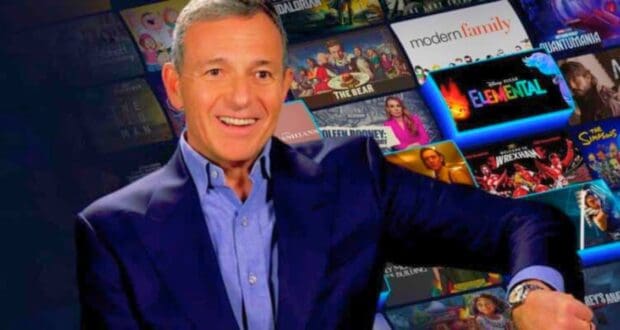 Bob Iger looking at watch with Disney+ catalog of shows in the background