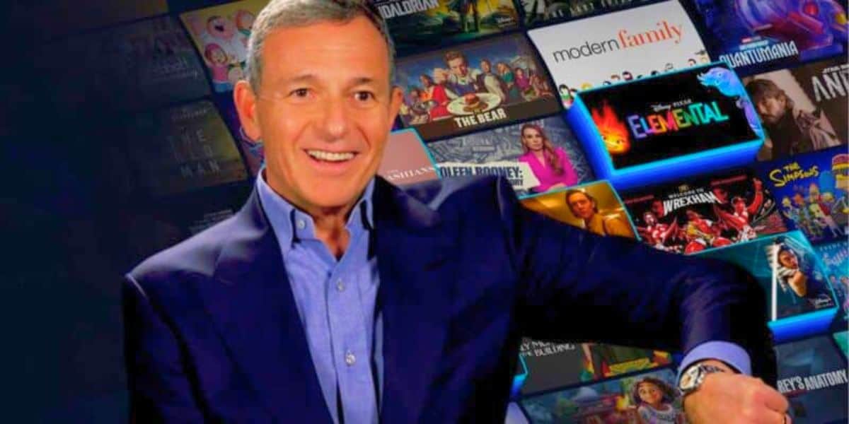 Bob Iger looking at watch with Disney+ catalog of shows in the background