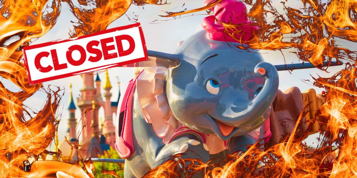 A colorful amusement park ride featuring a flying elephant is surrounded by animated flames. A red "CLOSED" sign is prominently displayed across the image. In the background, a whimsical castle can be seen.