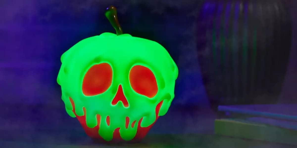 An apple coated in glowing green slime that forms the shape of a skull sits against a dark, foggy background. The apple's flesh is visible in red through the slime's eye and mouth holes, creating a spooky, eerie effect.