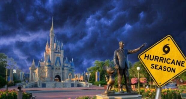 A darkening stormy sky looms over a castle reminiscent of Disney's Cinderella Castle. In the foreground, a statue features a man and a mouse holding hands. A yellow caution sign reads "Hurricane Season" with a hurricane symbol above.