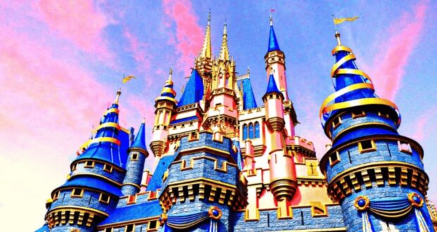 A vibrant castle with blue and gold turrets set against a pink and blue sky. The structure features intricate detailing and a fairytale-like appearance, creating a magical atmosphere.