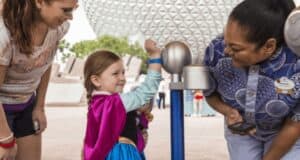 A little girl scanning her MagicBand and fingerprint to enter EPCOT at Walt Disney World Resort.