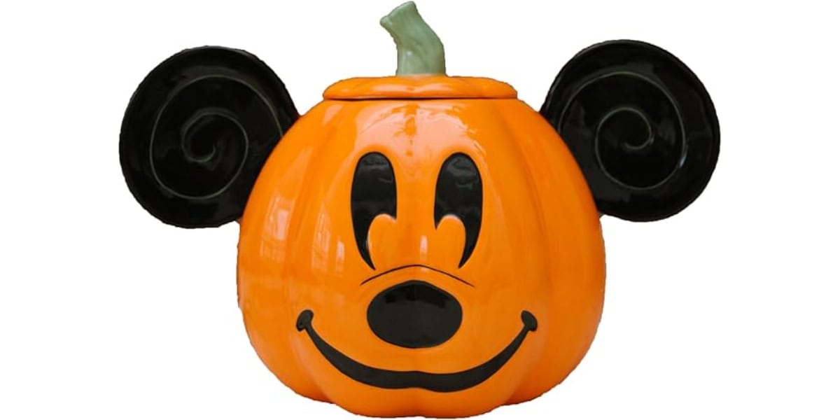 An orange pumpkin styled to resemble a cartoon mouse face with large black ears, a smiling expression, and a green stem on top.