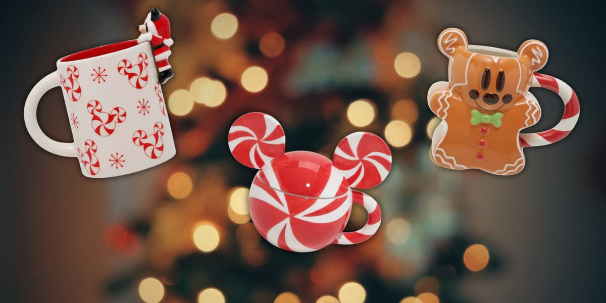Three Christmas-themed mugs with peppermint and gingerbread designs are displayed against a blurred background of festive holiday lights.